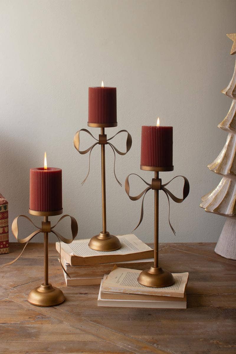 SET OF THREE ANTIQUE BRASS PILLAR CANDLE STANDS -BOW DETAIL: Gold / Metal / Large: 6.25" x 3.5" x 13.25"t;
Medium: 6.25" x 3.5" x 11"t;
Small: 6.25" x 3.5" x 8.75"t
